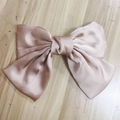 Pink satin bow hair clip with smooth silk texture on a natural wooden background - Spring Clips / Champagne