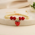Elegant gold-beaded adjustable bracelet featuring a red enamel strawberry charm on marble stand - Exquisite Enamel Strawberry Pendant (E000448YS)