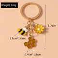 Detail of bee and sunflower keychain showing dimensions and weight of 8.4g on pink background - Bee Honeycomb Flower