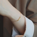 Bracciale minimalista in acciaio al titanio dorato con piccoli cubi sul polso - Bracciale / Oro