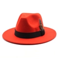 Close-up of red wool fedora hat featuring black ribbon band and elegant feather detail - Orange Red