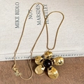 Collar con colgante de flor dorada con perla de resina ámbar y pétalos texturizados - Dorado