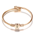 Close-up of rose gold cable bracelet with heart charm featuring engraved letter R - Letter R / Gold