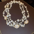 Detailansicht der mehrlagigen Perlenkette mit Goldakzenten und Strass-Anhängern - Weiß