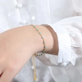 Bracelet bohème en or avec perles turquoise et breloque cœur porté sur une manchette - Bracelet en émail vert menthe / 17+5cm