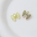 Detailed view of heart bow jewelry pendants with translucent yellow resin and gold metal base - Style 23
