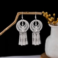 Silver ethnic tassel earrings with flower filigree disk in bohemian style on wood branch - Round Filigree Hollow Disc Tubular Tassel Style (E5825)