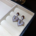 Elegante Herz- und Tropfenohrringe in Silber mit Zirkonia in einer beigen Schmuckdose - Silber