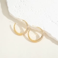 Macro shot of gold-plated C-shape hoop earring with cubic zirconia on white stone - White Zirconia Style (ES2275)