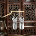 Ethnic style silver peacock bell tassel earrings displayed on a natural wooden branch - Shiny Silver Tassel Drop(E5983)