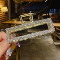 Rectangle gold metal hair claw clip with white rhinestones in a hand-held display - Square Rhinestone