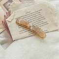 Detalle de pinza para el pelo de acrílico ámbar con textura de mármol sobre fondo vintage - Color Oscuro