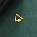 Nahaufnahme eines minimalistischen goldenen Doppelpfeil-Anhängers aus Edelstahl auf Textur - Doppelpfeil-Dreieck-Stil / Gold