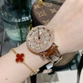 Luxury rose gold rotating watch with diamond bezel and brown leather strap on wrist - Brown Strap with White Rhinestones