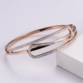 Detalle del brazalete de oro rosa con diseño entrelazado y pavé de circonitas - Oro rosa