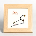 Wooden Leo constellation frame with natural yellow and pink stones on white background - Leo