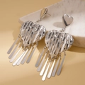 Dettaglio degli orecchini a cuore con nappe argentate e finitura a trama lavica - Argento (Perno in argento)