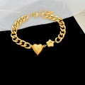 Close-up of gold stainless steel chunky chain bracelet with heart and star pendants - Gold - Heart