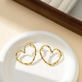 Detailed view of golden irregular heart earrings with molten lava texture in a ceramic tray - Heart Lava Texture / Gold