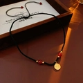 Dettaglio della perla rossa e del ciondolo Fu dorato su collana in corda nera - Collana Nera con Carattere Fu