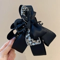 Detailaufnahme einer Haarklammer mit schwarzer Satinschleife und funkelndem Strass - Schwarz/Strass