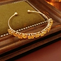 Detailed view of gold open bangle with square and oval yellow zircon gemstones - Gold-Yellow Stone