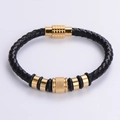 Dettaglio del bracciale in pelle nera intrecciata con inserti in acciaio dorato - Oro