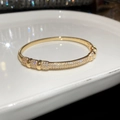 Dettaglio del bracciale placcato in oro con zirconi su un vassoio di ceramica bianca - Stile Pavé con Decorazione Cilindrica (3# Oro) / Oro