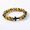 Close-up of yellow and black beaded bracelet with a central black cross charm - Yellow Black Spotted Black Cross Wood Bracelet