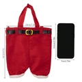Rote Weihnachtsmann-Hosen-Geschenktüte aus Filz mit Gürtel neben einem Smartphone gezeigt - Große Tasche (29cm*19cm)