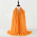 Orange pleated cotton linen scarf draped on a mannequin with textured frayed edges - Orange