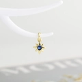 Detailed view of a gold starburst pendant with a center blue zircon on a jewelry stand - Gold with Dark Blue Zirconia