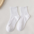 Flat lay of premium white cotton crew socks featuring a classic ribbed texture design - Crew / Cream