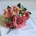 Draufsicht auf Seidenrosenstrauß mit rosa Blütenblättern auf einem offenen Magazin - Altrosa