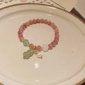 Detailed shot of pink strawberry quartz and shell pearl bracelet on white ceramic plate - Style 29 Red Gourd (Melon)