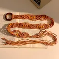 Détail d'une ceinture bohème faite main avec perles en bois et anneau sur des livres - Style Tissé à Perles en Bois Vintage