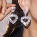 Elegant heart-shaped rhinestone dangle earrings in silver finish worn by a model - Silver Heart Full Rhinestone Long Pendant Style (DTE1516101S-W)
