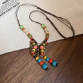 Vue détaillée du pendentif papillon ethnique avec perles en céramique et cordon brun - Coloré