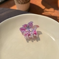 Detailed top view of a lily-shaped purple and pink gradient hair claw on a ceramic plate - Rose Pink Flower - Small Claw