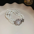 Détail d'un bracelet de perles multicouches avec fermoir fleur étincelant sur plat blanc - 12# Bracelet-Fleur Argent Losange