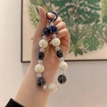 Beaded keychain with deep purple polarized beads and cream white accents in hand - Deep Purple Milk White