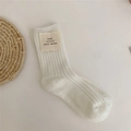 White wool knit mid-calf sock featuring a minimalist ribbed cuff and beige fabric label - White