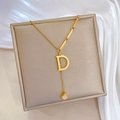 Collier doré minimaliste avec pendentif lettre D et cube géométrique sur fond de soie - Or (N132)