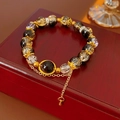 Macro-opname van vintage kralenarmband met gouden accenten en hartbedel op houten doosje - Zwart & Goud Stijl