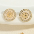 Détail macro de boucles d'oreilles camélia dorées avec cristaux et texture perle - Boucles d'oreilles clous disque camélia doré