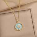 Detailed close-up of a gold necklace with turquoise enamel and zircon star in a jewelry box - Blue