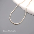 Minimalist freshwater pearl necklace with 3.5mm baby pearls on a white ceramic stand - Seed Beads