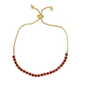 Detail of adjustable gold bracelet featuring vibrant red cubic zirconia in claw settings - Red