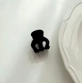 Minimalistische mattschwarze Haarklammer für Mädchen auf weißem Keramikteller präsentiert - Schwarze Haarkralle