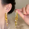 Elegant gold tassel earrings with sparkling rhinestones and long cascading metal fringe - Long Round Disk Tassel Style / Gold